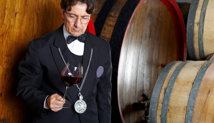 an image showcasing a sommelier wearing a delicate silver necklace adorned with a miniature wine glass pendant, accentuating their refined taste and expertise in the world of wine.